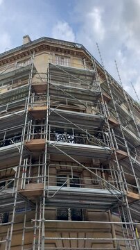 Un immeuble avec des &eacute;chafaudages au format vertical.