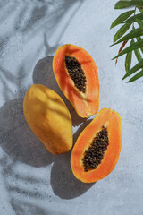 fresh, ripe papaya sliced ​​open on orange background, harsh sunlight