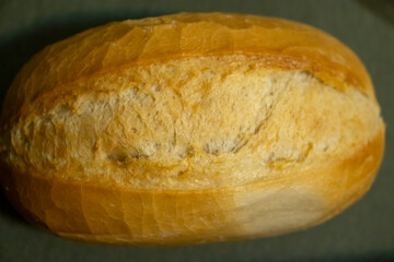 Freshly baked artisan bread loaf on a wooden surface, showcasing its golden crust and soft interior texture, perfect for culinary and food photography