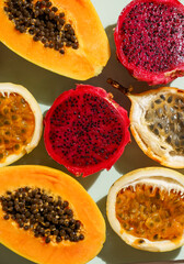 exotic tropical fruits,  passion fruits and dragon fruit, ripe papayas. on a bamboo tray with green leaves, stone background