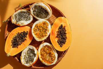 exotic tropical fruits,  passion fruits and dragon fruit, ripe papayas. on a bamboo tray with green leaves, stone background