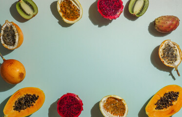 exotic tropical fruits,  passion fruits and dragon fruit, ripe papayas. on a bamboo tray with green leaves, stone background