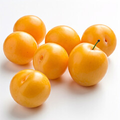 A cluster of vibrant yellow plums, nestled against a pristine white background