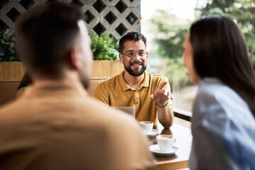 Young people relaxing on coffee break and communicating in a café.