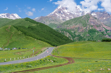 Panoramic view from the grassy hill on the Kazbek mountains and the green valley