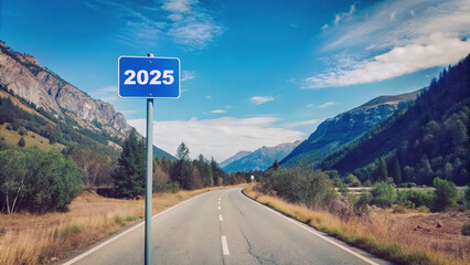 Sign indicating the year 2025 along a winding mountain road under a clear blue sky in a serene natural landscape