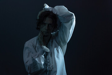 The tragic hero in a white vintage blouse experiences confusion and horror, a portrait in the...