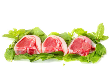 Fresh uncooked lamb loin chops and mint leaf on white background. High quality meat product cut by butcher in perfect size for cooking. Food supply chain and agriculture industry.