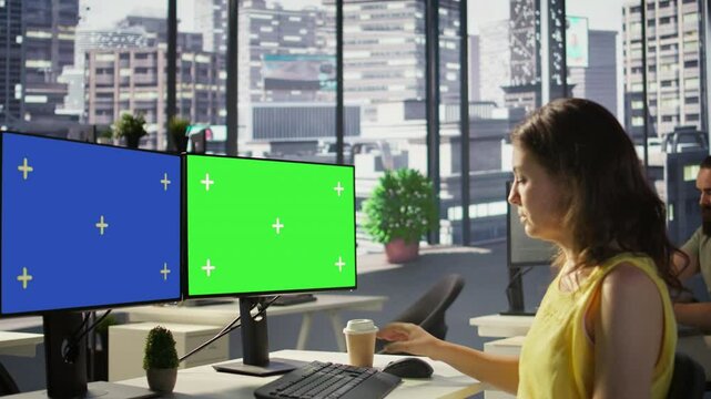 Employee using multi monitor isolated screen computer to analyze datasets, comparing accounting figures. Woman using chroma key PC to solve tasks for team project, camera B