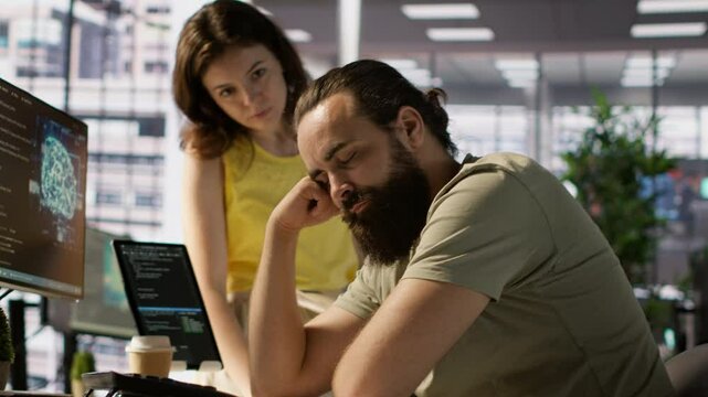 Exhausted developer caught asleep at desk by manager while developing AI machine learning company tech. Supervisor waking up tired sleeping employee while training predictive models, camera A