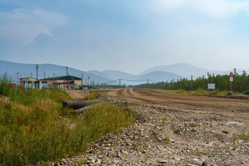 Remote construction site with dirt road and distant mountains