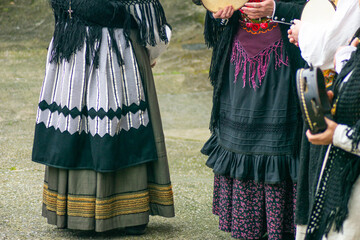 four women playing the tambourine in traditional Galician costumes dancing at the Raigame ethnographic festival. Galicia.