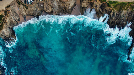 Aerial View of Turquoise Waves Crashing on Rocky Coastline at Little Fistral Beach, Newquay, UK