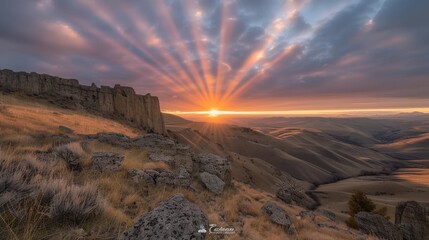 Obraz premium Majestic Sunrise Over Rolling Hills and Rock Formations