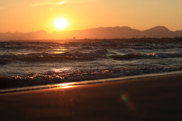 Sunset at sea. Balearic Sea, Salou, Spain. Beach, sea, small waves. Evening landscape on the coast....