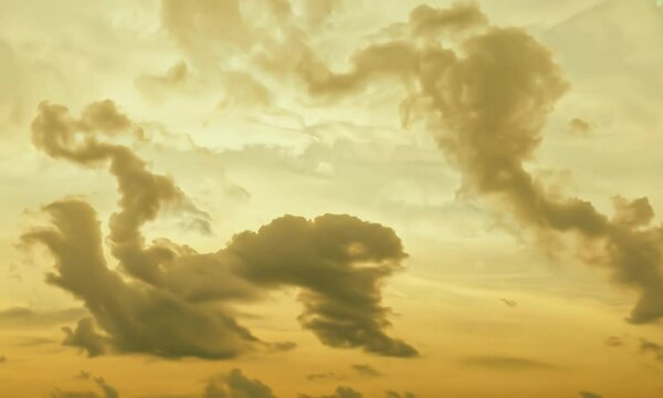 Smoky silver clouds on a warm mustard background. Video