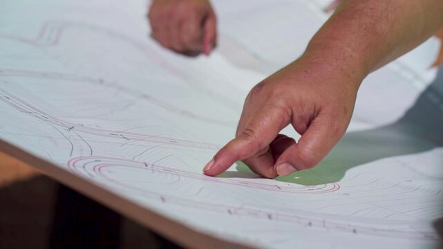 Slow motion video of a group of workers reviewing plans for a road construction project