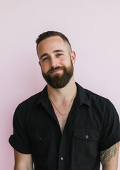 Obraz premium portrait of a handsome male model with a short beard, short hairstyle, black shirt unbottoned with gold chain, light pink background