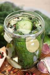 Making pickles. Fresh cucumbers and spices in jar on wooden table, closeup