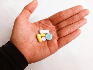 hand with pills. various types of medicine in hand. a hand holding various medicine isolated on white background.