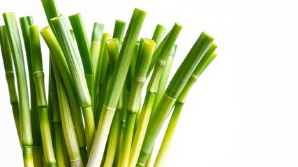 Fototapeta premium A cluster of crisp, emerald green scallions stands tall on a pristine white background, their delicate white and