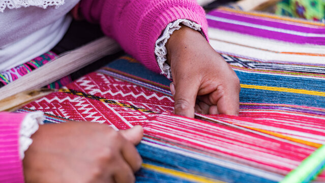 Close up Andean woman weaving alpaca textiles tecnique