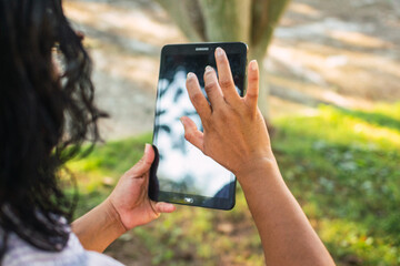 40 year old Latin woman, working on her laptop in the park, empowered female entrepreneur