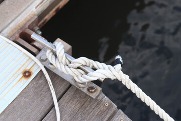 Mooring post, a mooring knot on a yacht pier. The yacht's mooring ropes are attached to the knecht. Knecht on the deck on the pier for fastening ropes. Knecht for mooring and fastening ropes