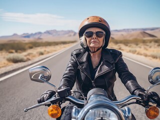 Elderly woman confidently rides a motorcycle down a desert highway under clear skies in a vast landscape