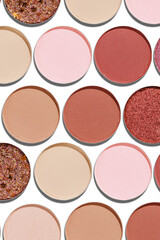 Colorful Swatches eyeshadow refills as minimal geometric pattern. Matte and glitter pans red brown pink shade with sun shadows, detail texture, cosmetic, beauty product, makeup, warm color scheme