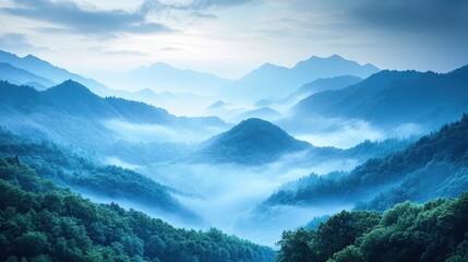 Fototapeta premium Misty blue mountains at dawn with soft light over forested hills