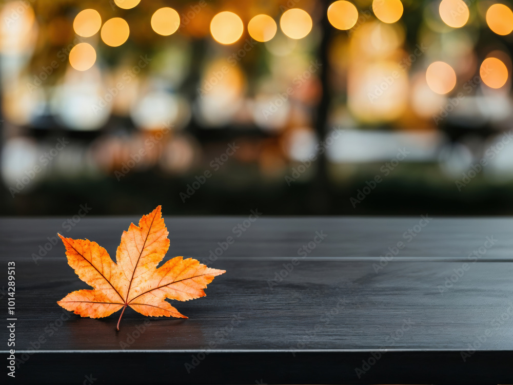 Poster bright orange maple leaf lying on empty black table during autumn