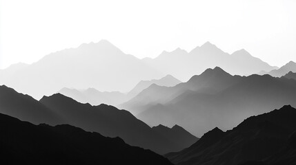 Fototapeta premium Majestic mountain range silhouetted against a light sky at dawn in black and white tones