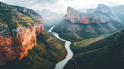 Vermilion-hued canyon walls, winding river, and lush greenery, aerial view, soft overcast light, serenity and awe, a realistic photo image. Lush Canyon. Illustration