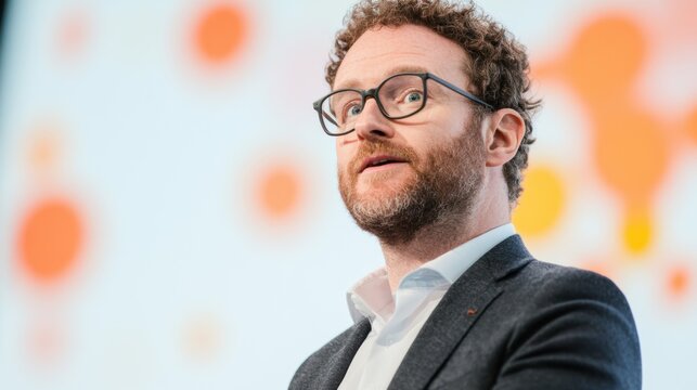 A dynamic speaker captivates the audience with valuable insights during a conference in a vibrant setting in October 2023