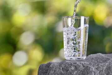 drinking water pouring into glass on stone