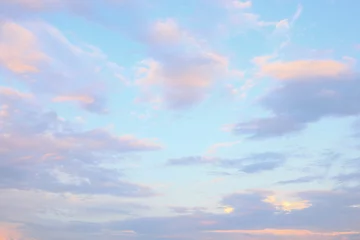 Fotobehang Soft pastel clouds drift across a bright blue sky during early morning or late afternoon in a tranquil landscape. © Mr. Music