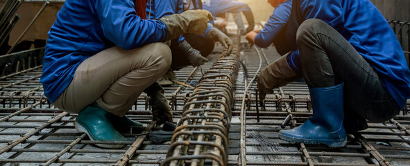 A group of builders is busy constructing a metal structure