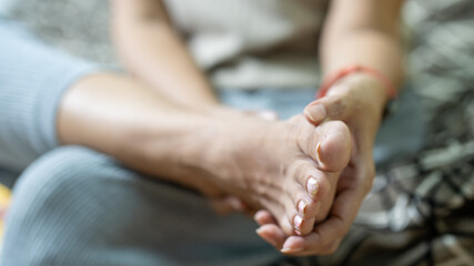 Asian women's hand scratching feet, itching foot, house carpet dermatitis, fungus, fungal bacterial infection, allergic response, eczema. Foot care concept.