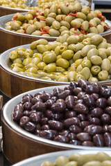 Fresh olives in barrels on street market or in grocery shop. Snack containing vitamins