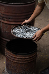 Hand holding firewood with rustic oven