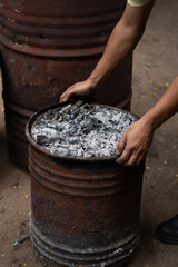 Hand holding firewood with rustic oven