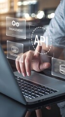 Naklejka premium API: a businessman using a laptop with a hologram of API, virtual interface that hologram of API,API integration, API development, JSON, API documentation, Application prgramming interface