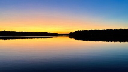 Fototapeta premium Serene sunset over a calm lake, reflecting vibrant colors in the water.