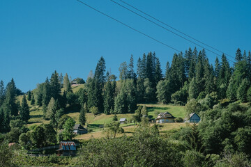 A serene landscape with cottages nestled among trees on a bright summer day in the countryside