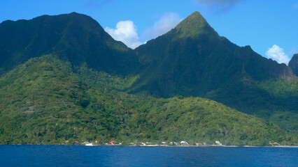Rugged mountainous and forest tree covered landscape and ocean of tropical Moorea Island Tahiti in...