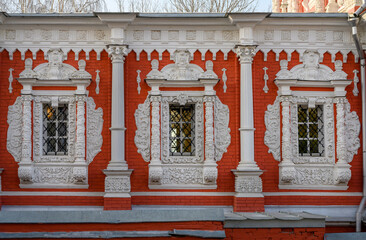 Windows with stucco platbands and bas-reliefs against the background of the red brickwork of the Cathedral of the Most Holy Theotokos, built in 1719 in Nizhny Novgorod, Russia