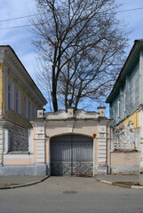 A brick wall with a 19th-century gate on a street in Nizhny Novgorod, Russia