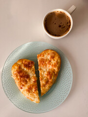 Pies with cheese and coffee on a blue plate on a white background