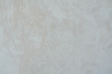 Textured Plaster Wall Background. A close-up of a textured plaster wall with an abstract rough surface. The neutral light beige color and irregular patterns create a natural and artistic backdrop. 